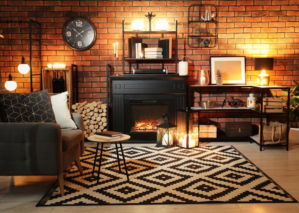 Warm dark living room with fireplace, armchair and decor at night.