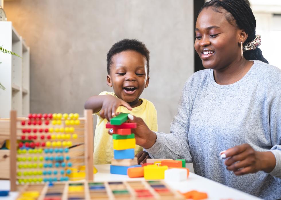 Kindergarten teacher with child and blocks.