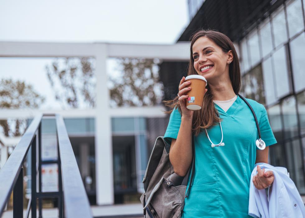 A health care worker leaving a building in uniform.