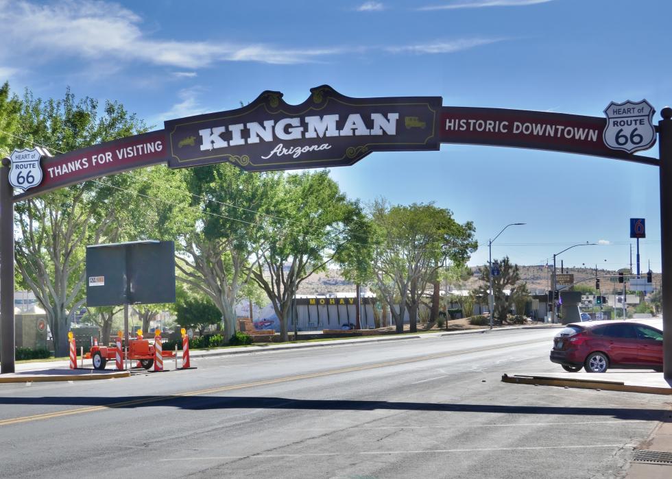 A sign over a street that reads, thanks for visiting Kingman, Arizona, Historic Downtown, with a Heart of Route 66 emblem.