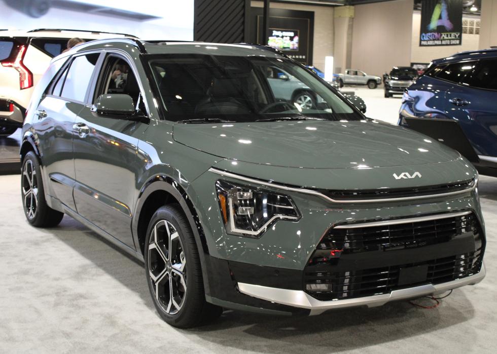 A muted light green KIA Niro on display at a show.