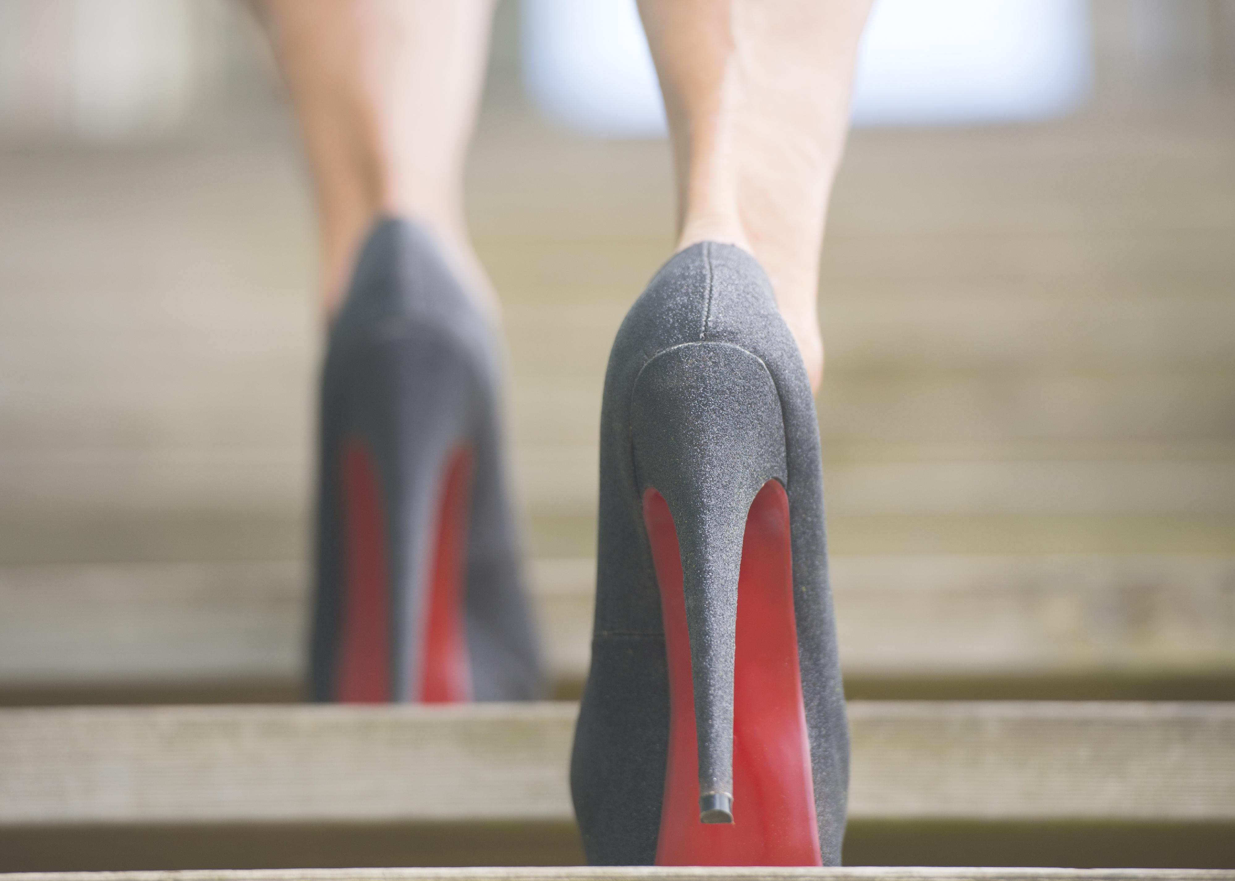 Close-up of a woman in high heels walking up stairs.