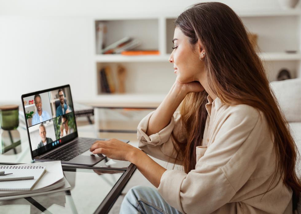 A woman in a virtual meeting while working at home.