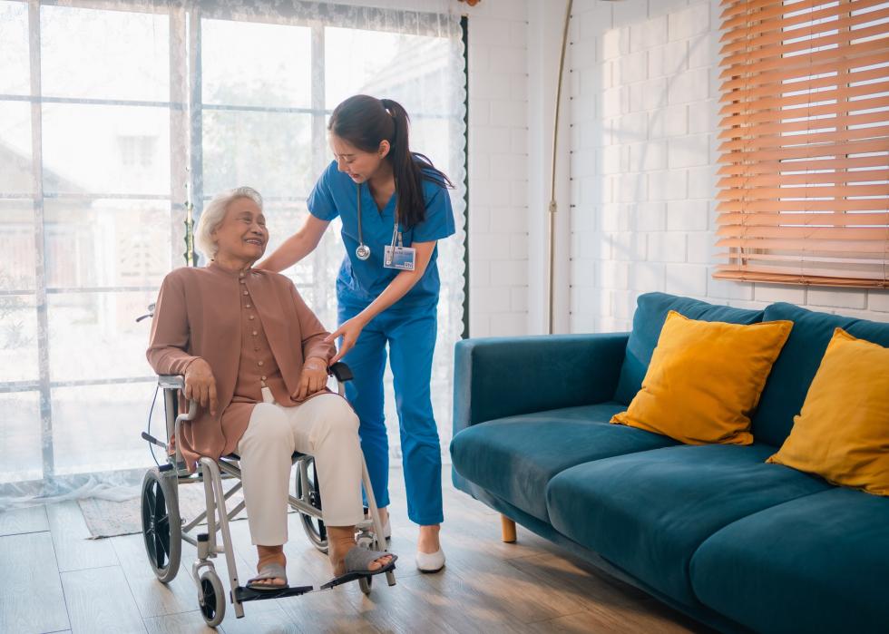 Nurse with an older woman in a wheelchair at home.