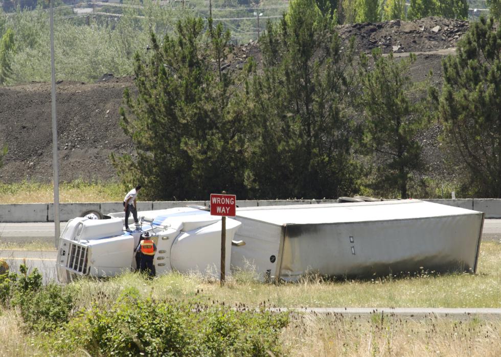 Large semi truck overturns on a freeway exit ramp