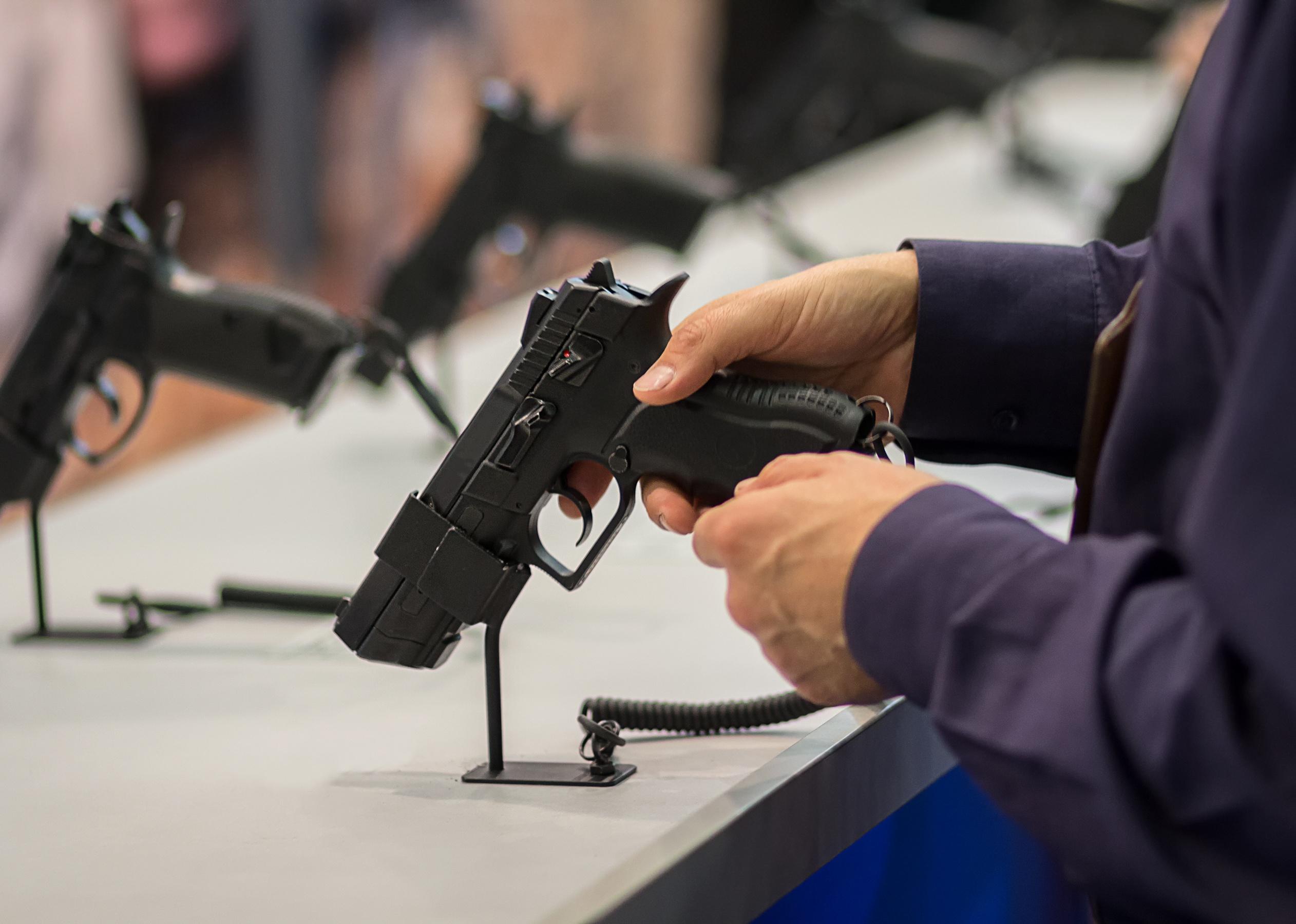 Close up of a person holding a gun on sale.