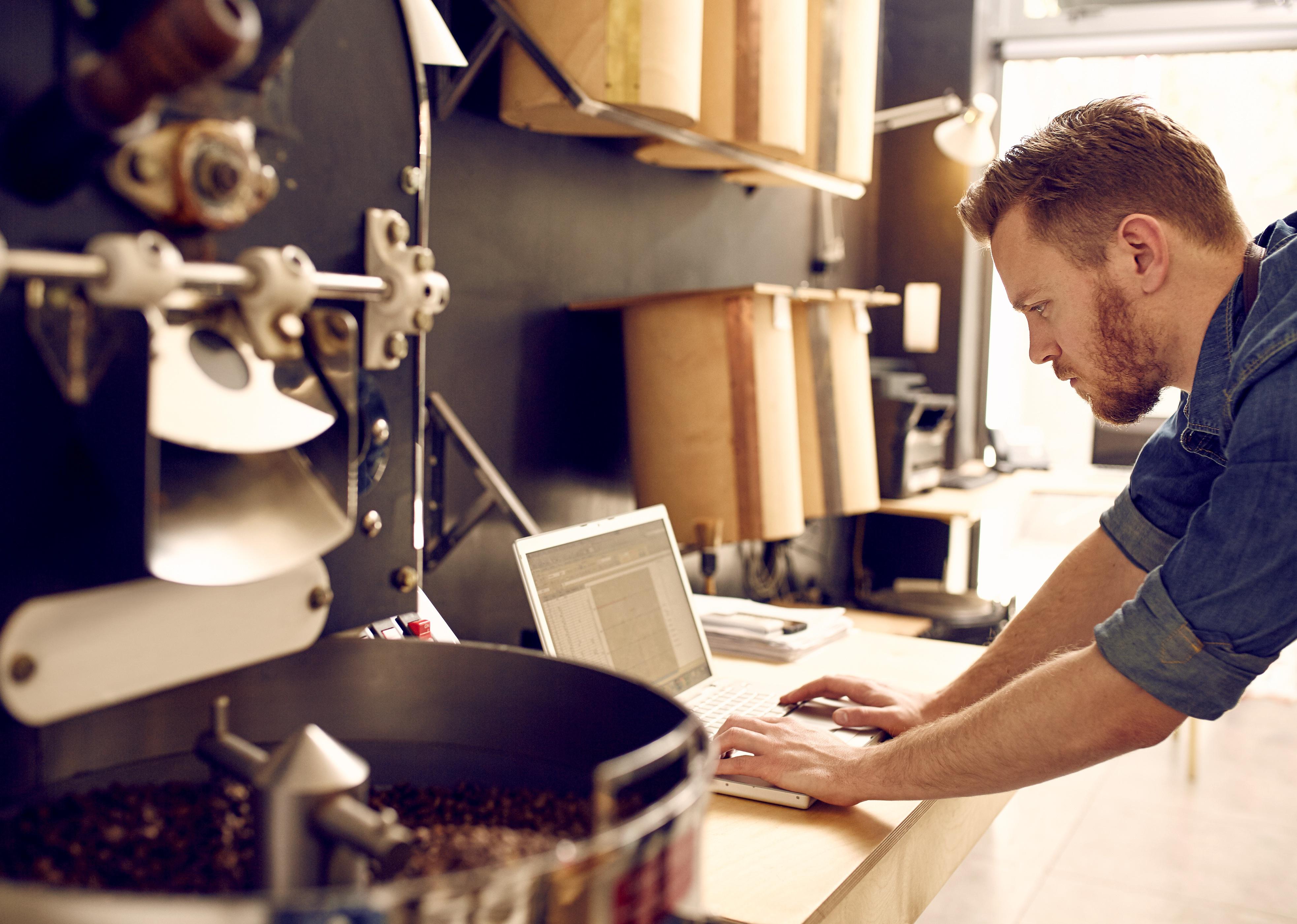 Business owner of a coffee roaster checking their laptop.