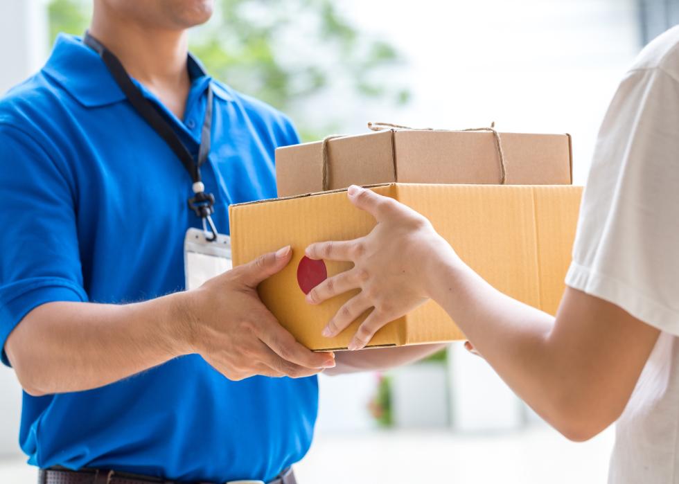 Woman accepting a delivery of boxes from courier.