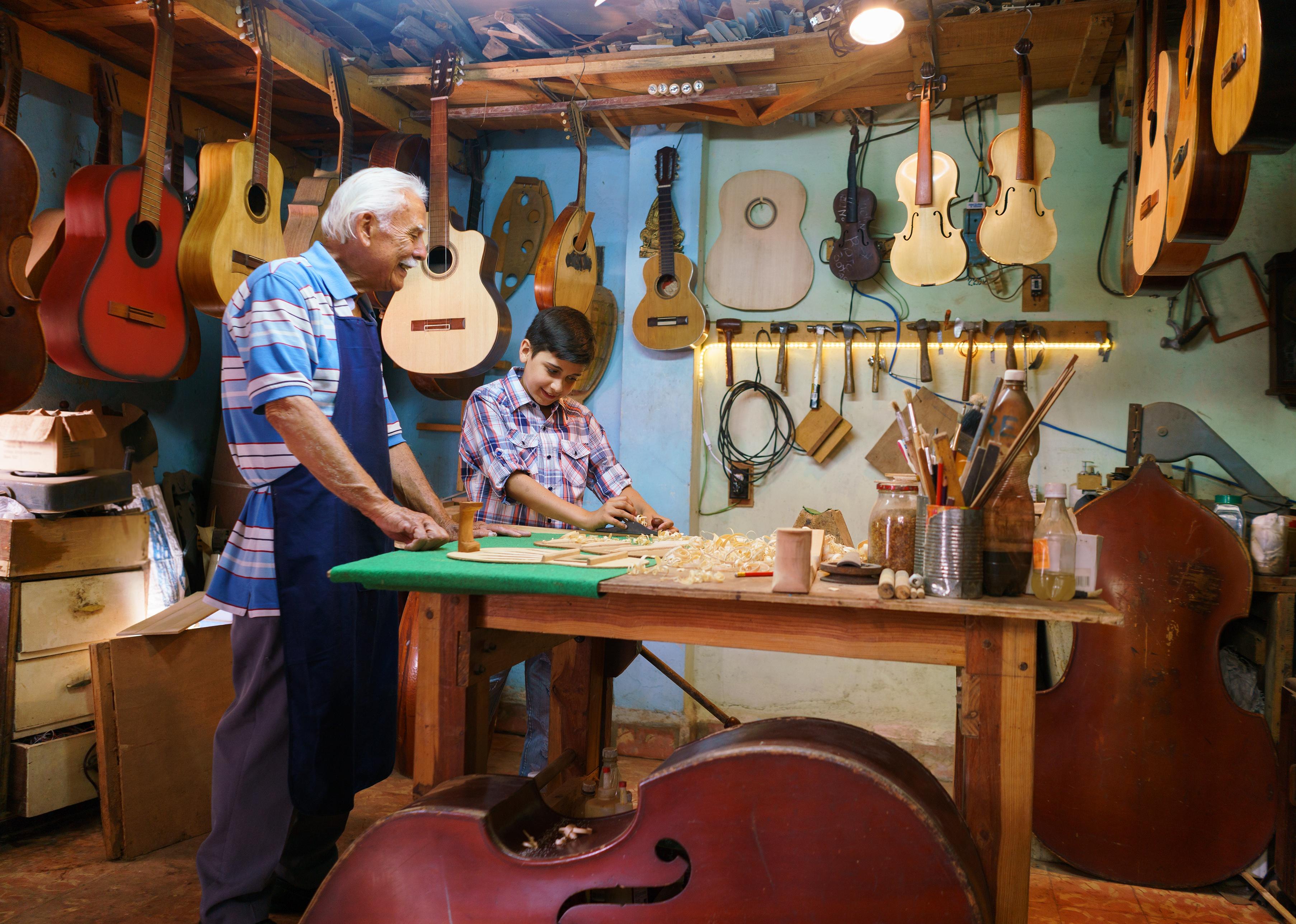 Grandparent with grandchild in a lute maker shop.