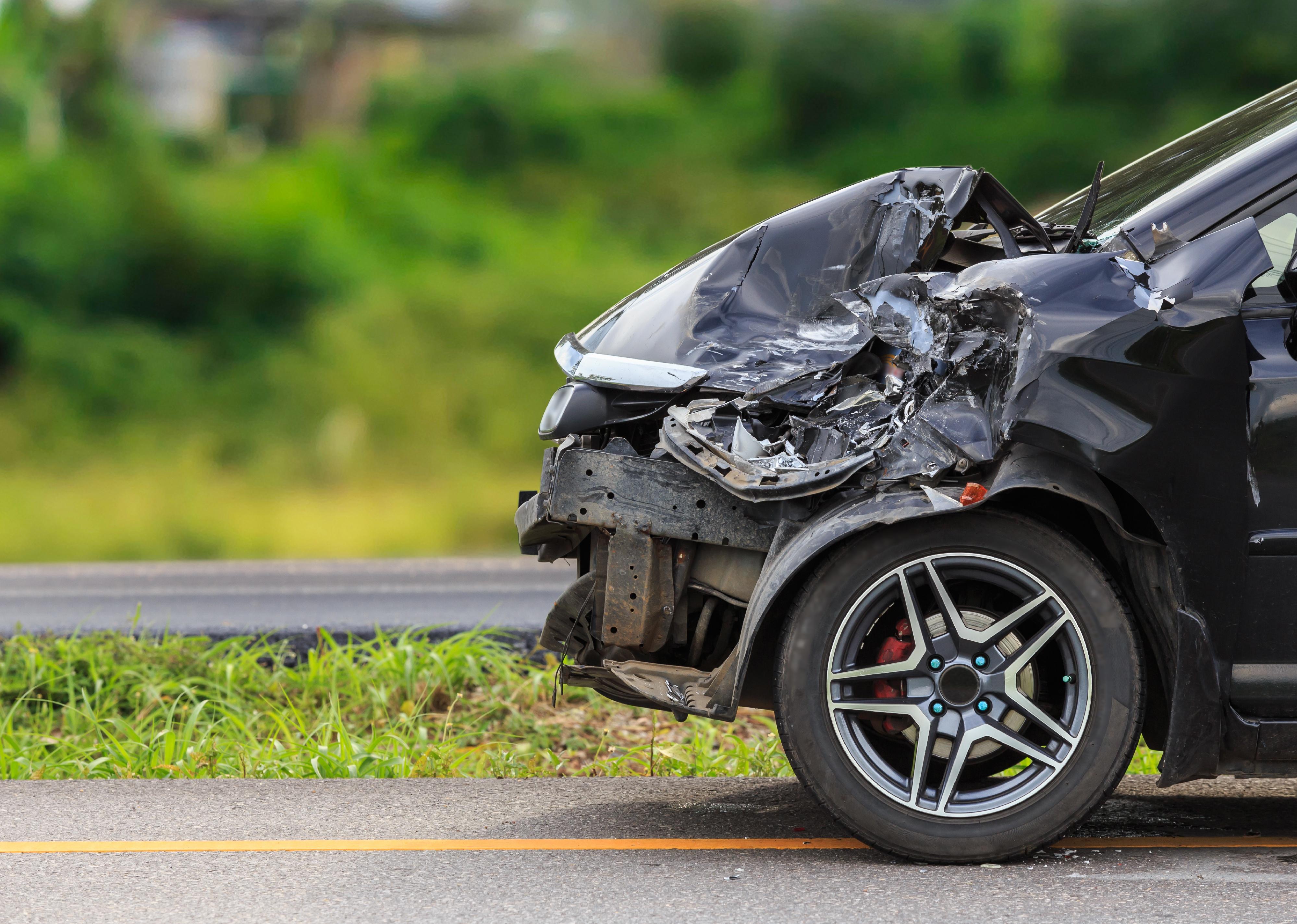 Front of black car damaged by accident.