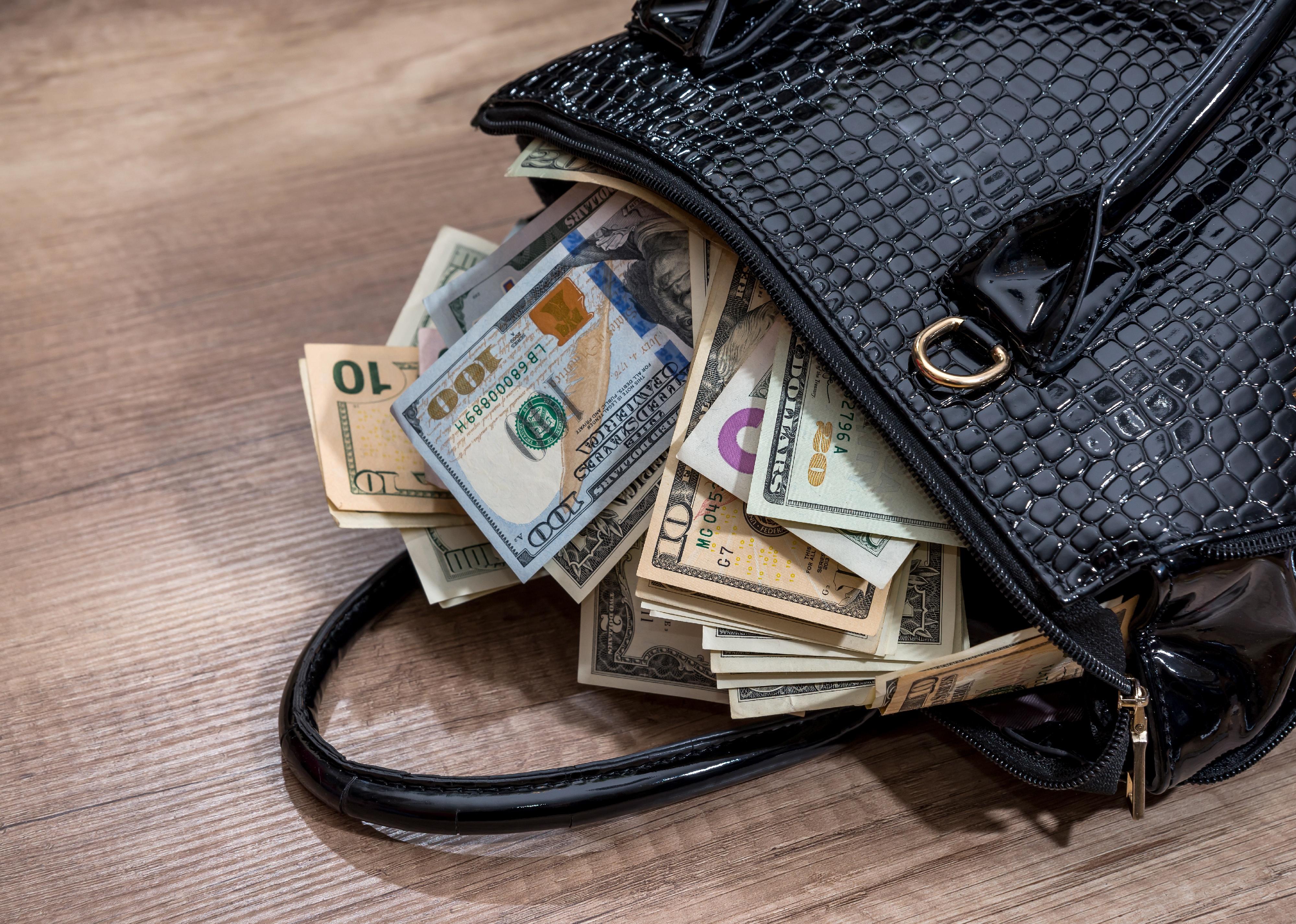 A black handbag full of money