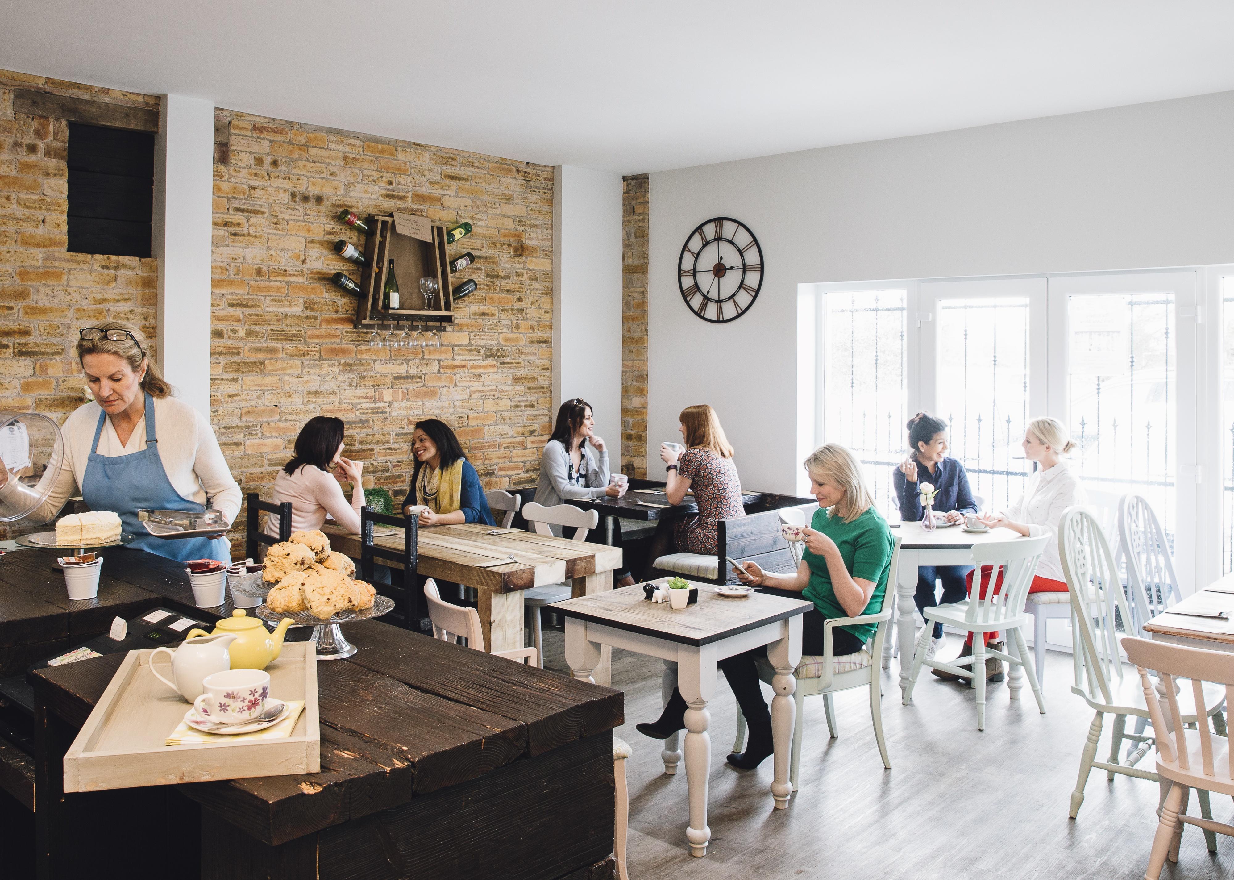 Room shot of a busy cafe full of people socializing.