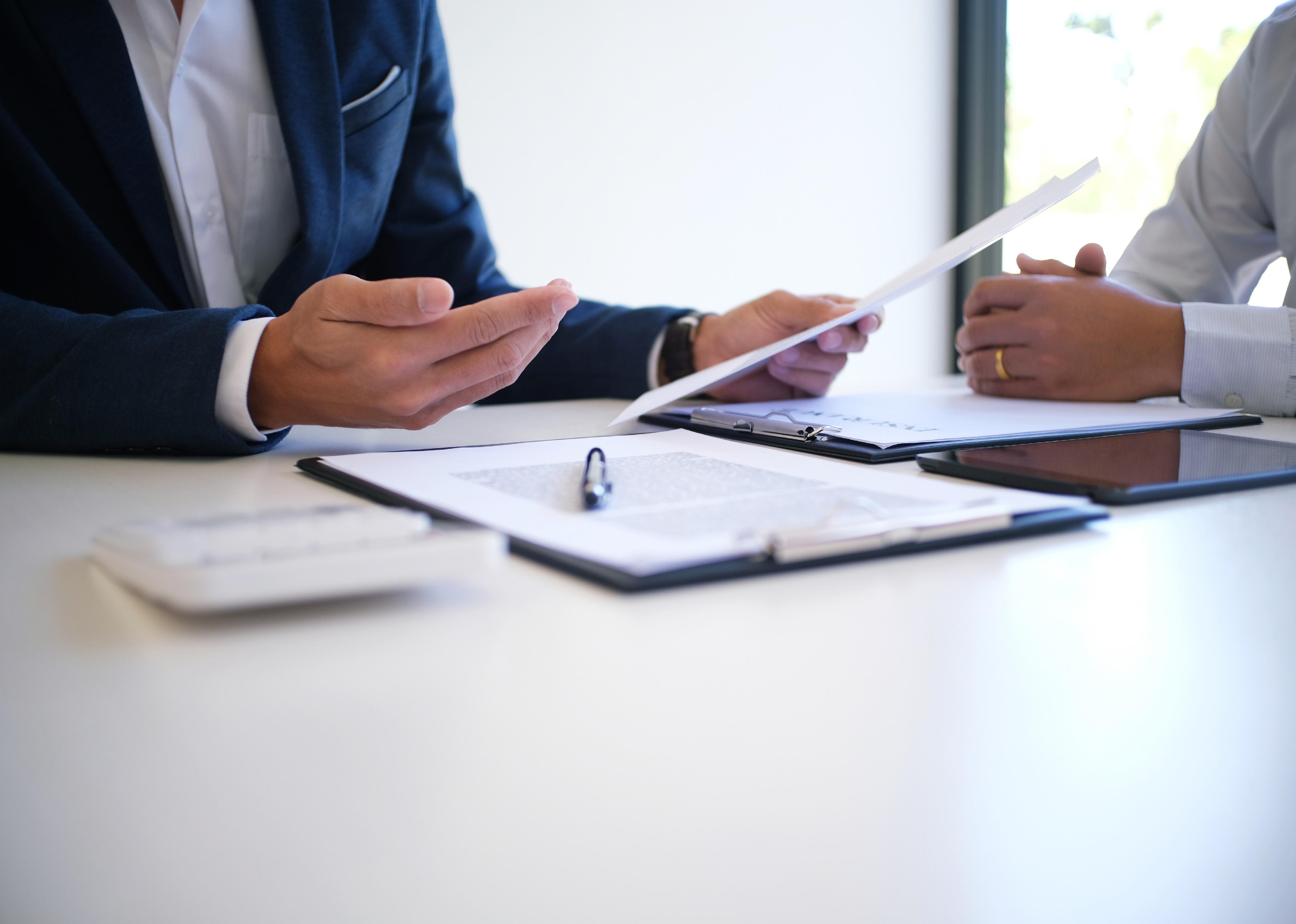 Two people at a table reviewing documents.