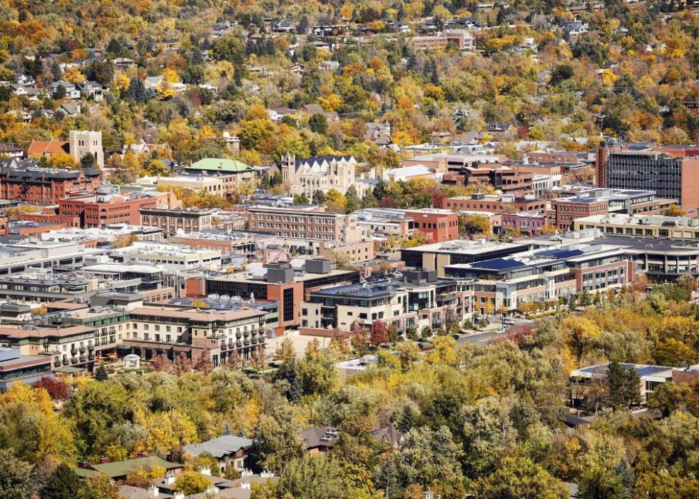 An aerial view of a town center surrounded by autumn foliage. 
