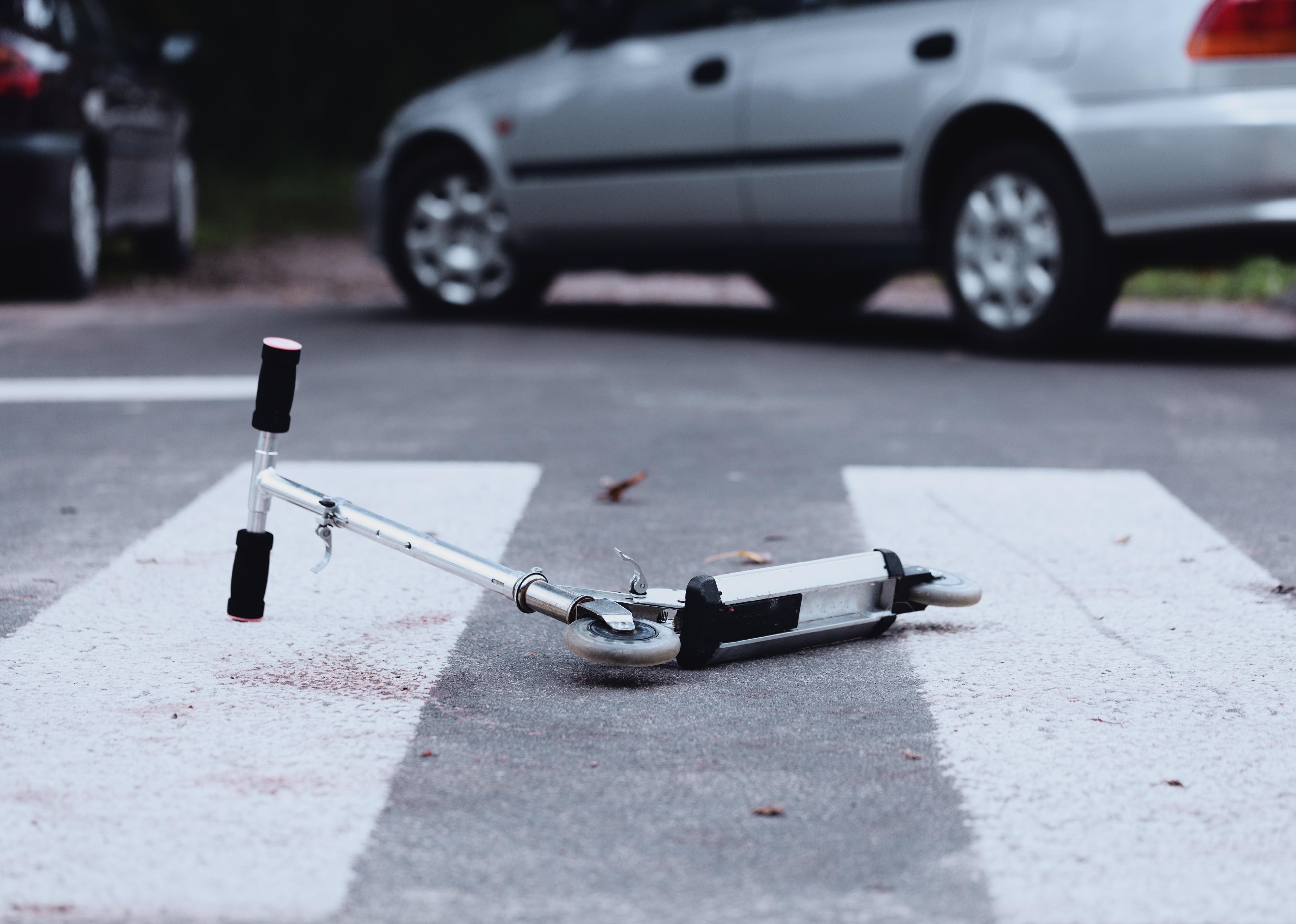 Close-up of a scooter on a pedestrian crossing.