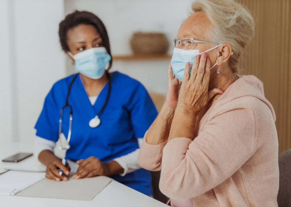 An elderly woman wearing a mask at a doctor's appointment.