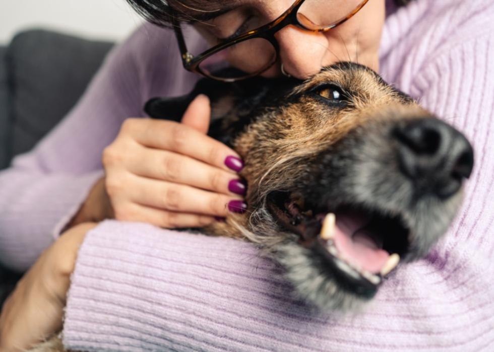 A woman hugging a dog.