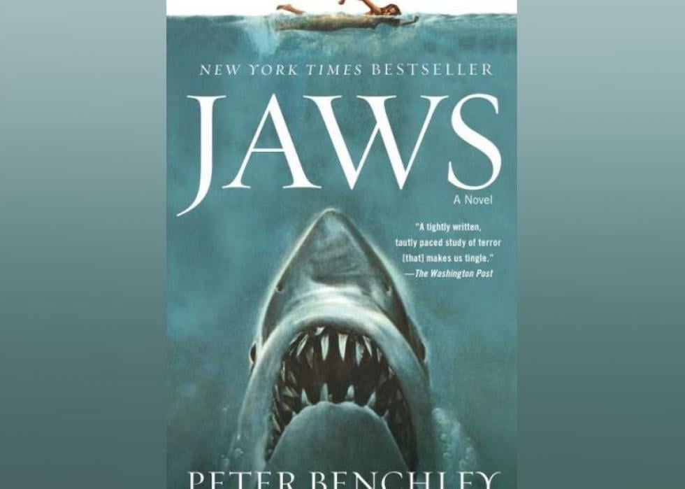 The illustrated cover shows a woman swimming with a massive and terrifying great white shark emerging from the depths beneath her.