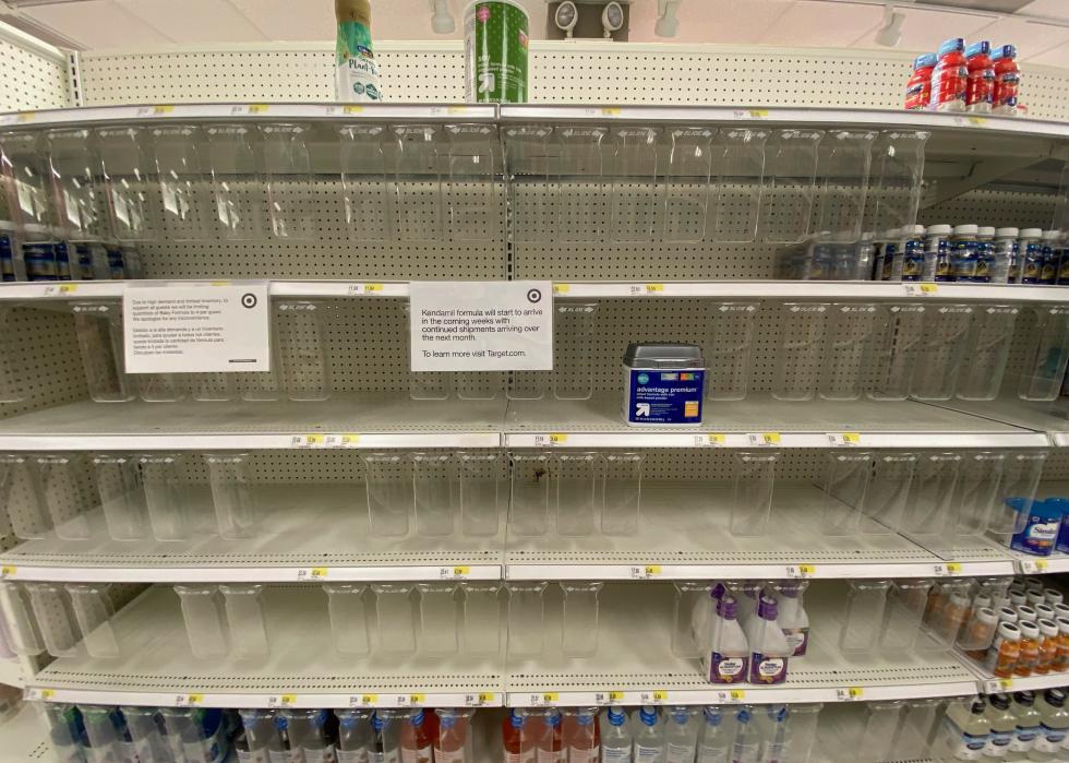 Empty shelves in the baby formula aisle at Target with a note taped to a shelf saying there are shipments expected in the coming weeks and months.