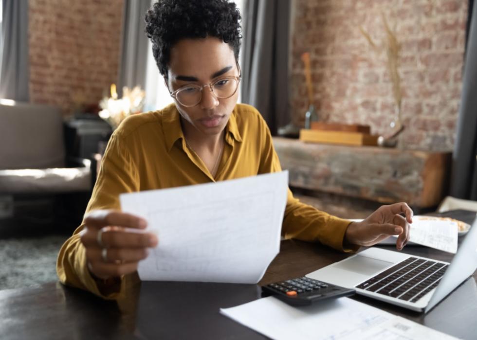 A woman reading a bill.