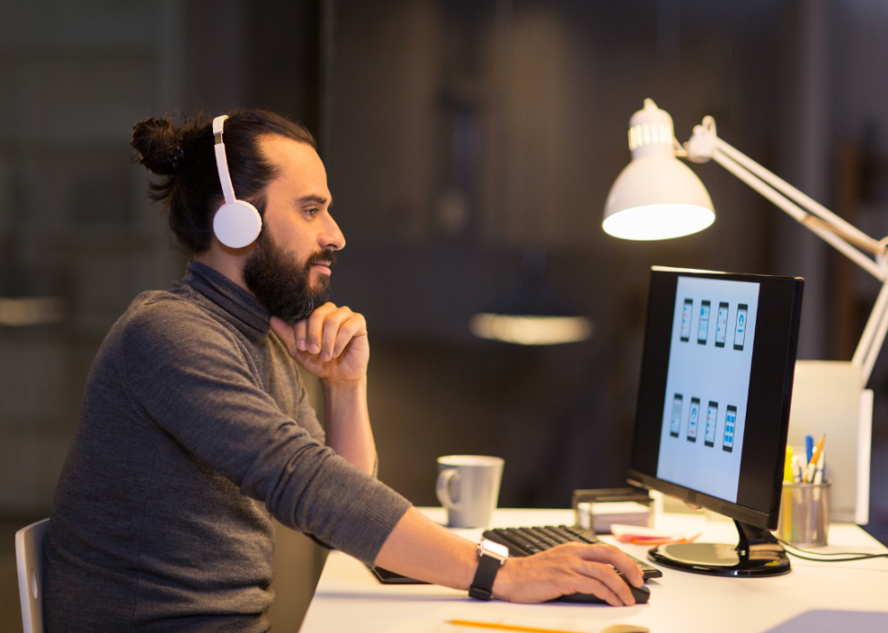 A man working on a computer while wearing headphones.