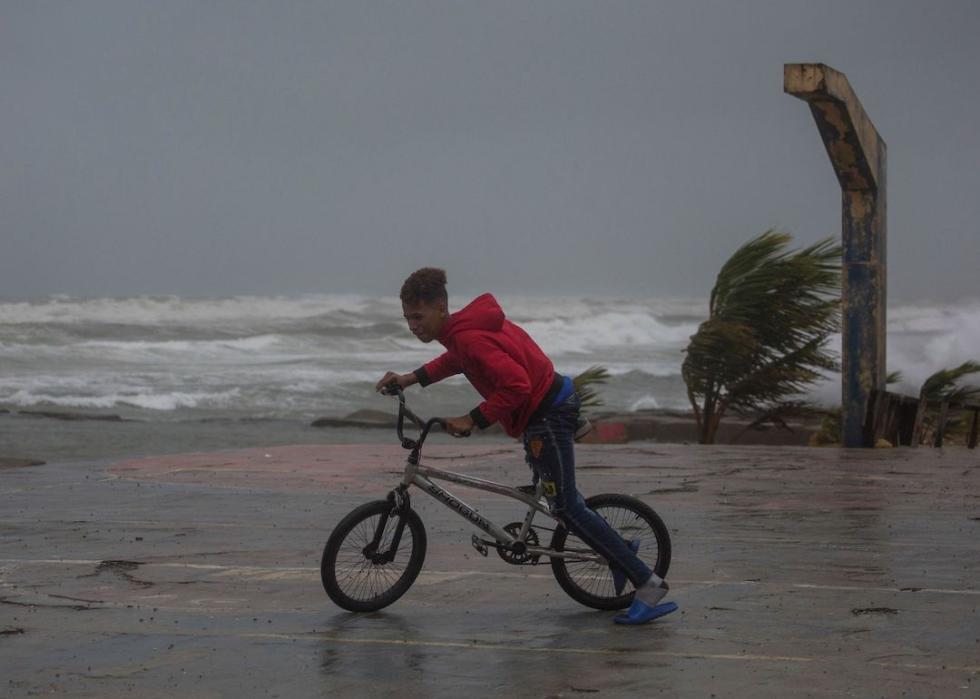 A child rides his bicycle at the seaside in Nagua, Dominican Republic, on September 19, 2022, as Hurricane Fiona passes through the country. 