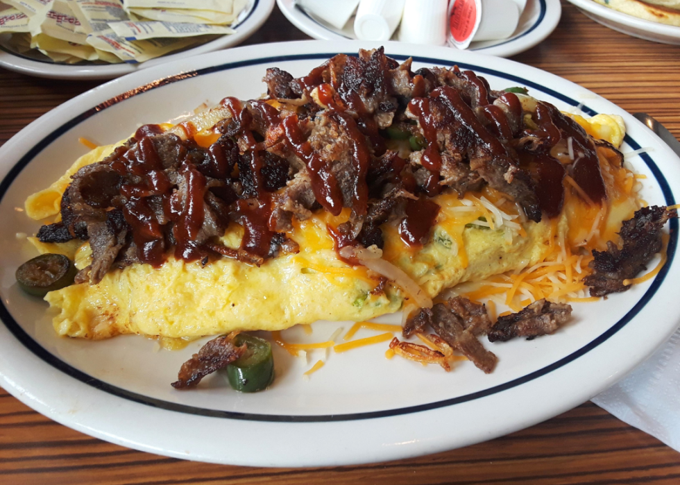 An omelette with jalapenos and bacon on a plate.