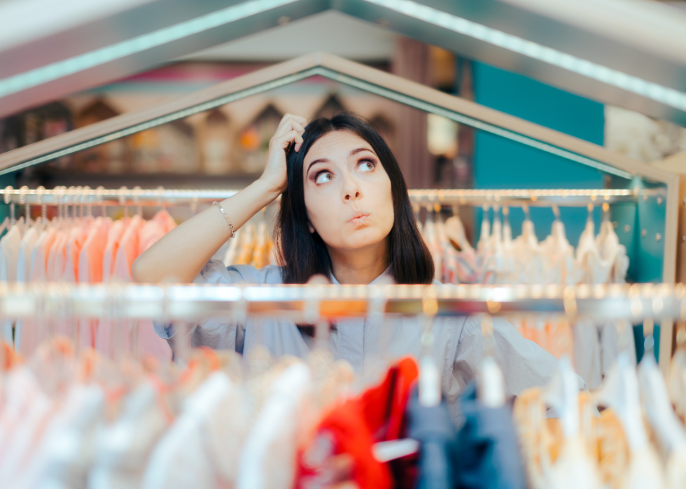 Indecisive woman shopping in clothing store.