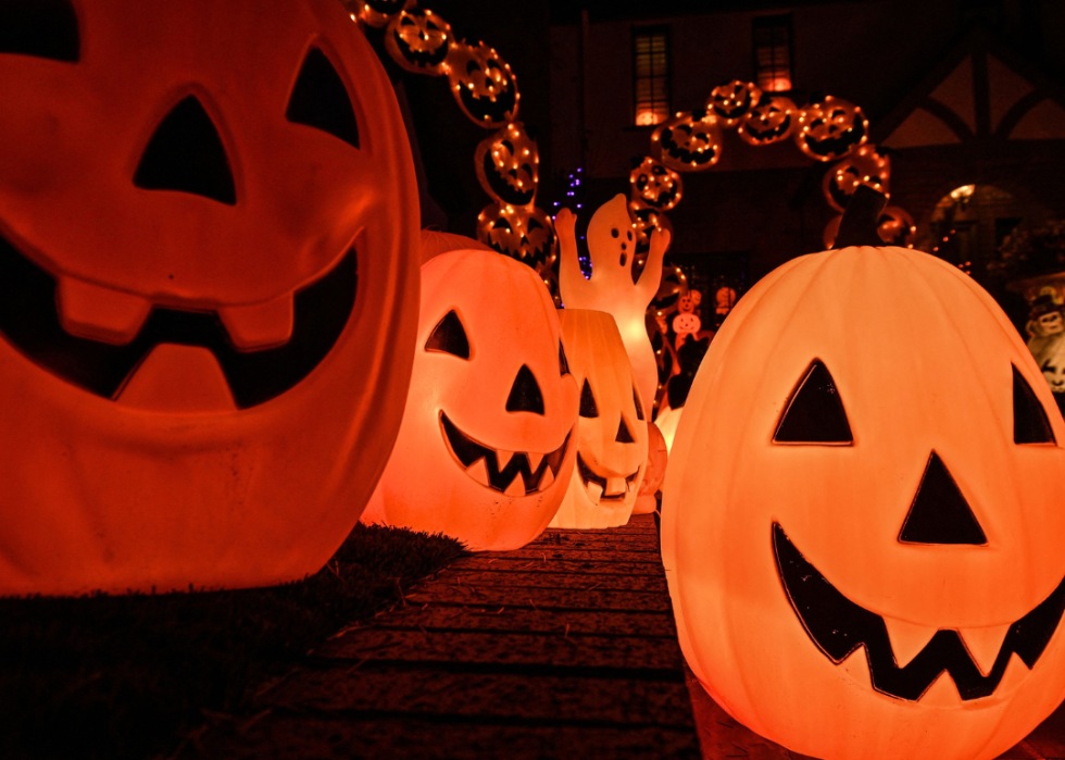 A yard entrance lined with giant pumpkin lights.