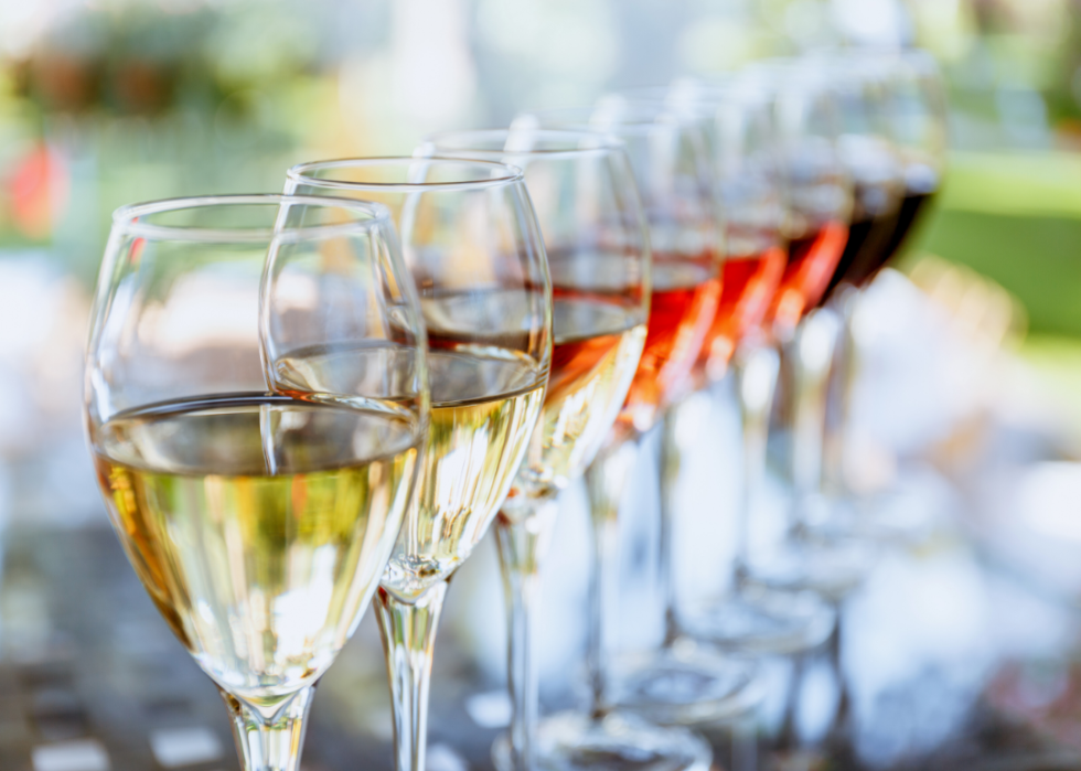 A lineup of eight glasses with different wines arranged from light to dark.