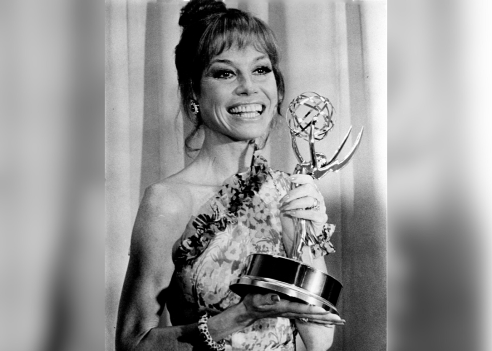 Mary Tyler Moore holding an Emmy statue.