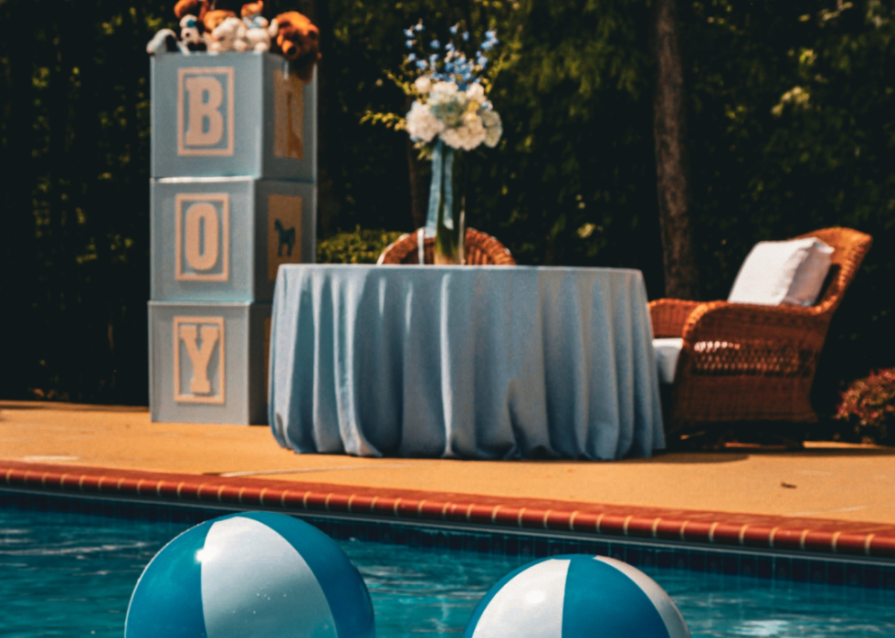 A baby shower at a pool with large decorative blocks that spells the word boy. 