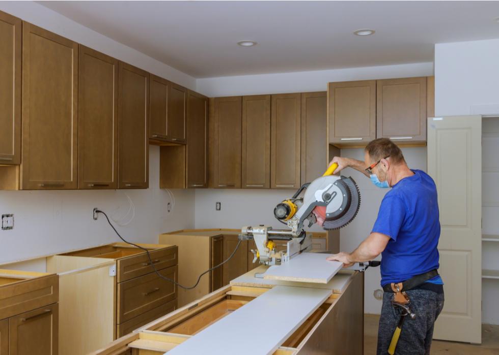 A man using a circular saw rotating to cut wood during a kitchen remodel