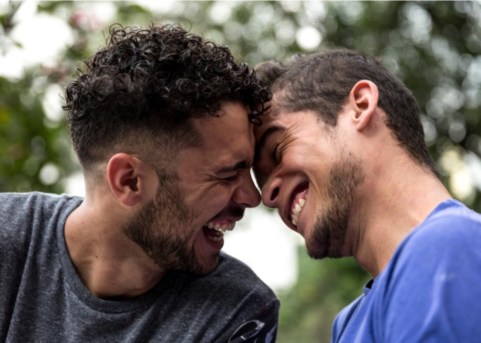Two gay men touching foreheads and smiling