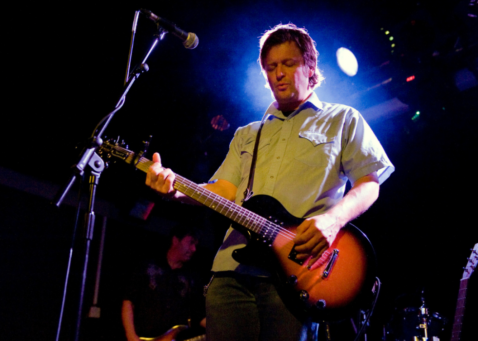 A guitarist performs on stage. 