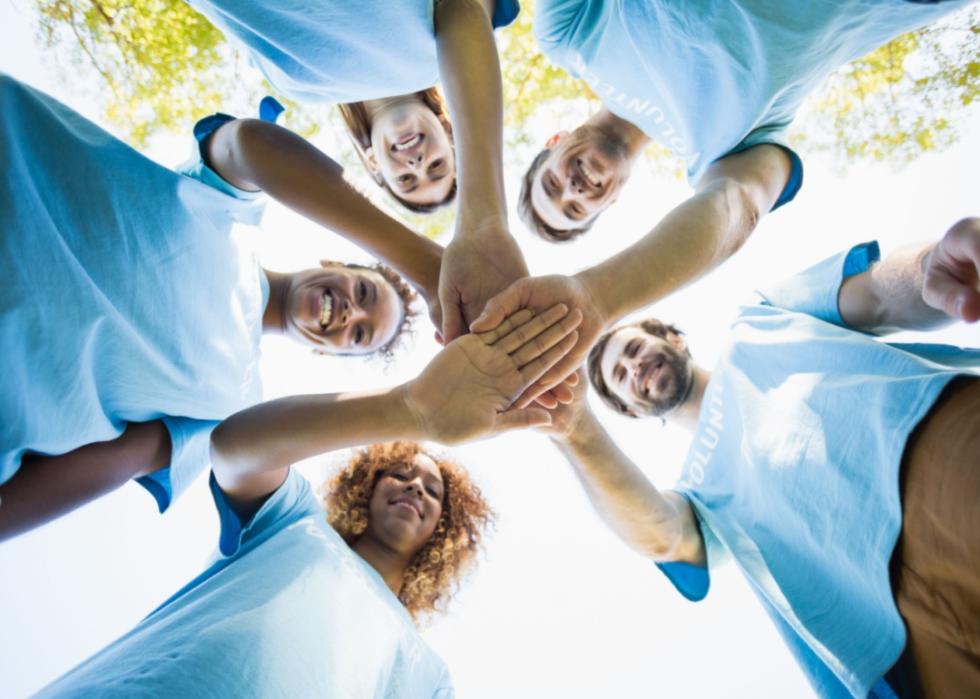 A group of volunteers putting their hands together.